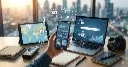 A close-up of a hand holding a smartphone showcasing data analytics. It is surrounded by floating digital icons and multimedia devices on a wooden desk, symbolizing the convergence of digital tools and media studies.